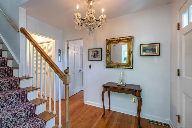 a view of a hallway with wooden floor and stairs