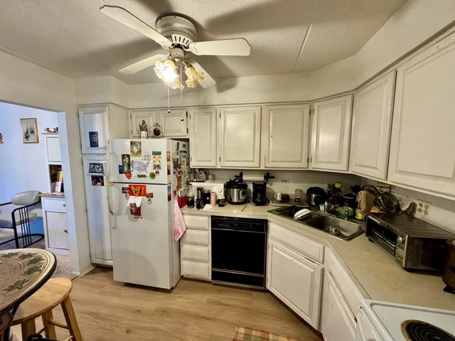 a kitchen with refrigerator a stove a sink and cabinets