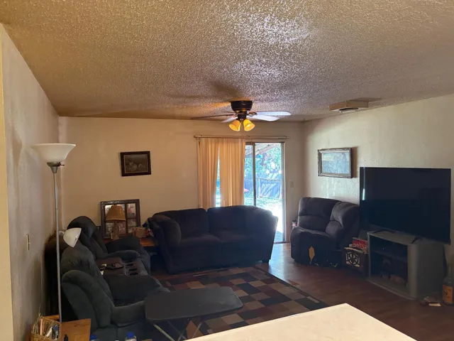 a living room with furniture a ceiling fan and a window