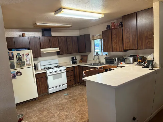 a kitchen with a sink a stove a refrigerator and cabinets