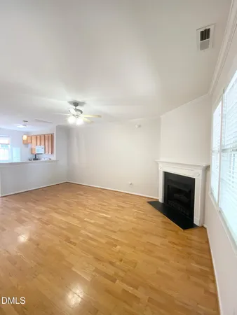 an empty room with windows and fireplace