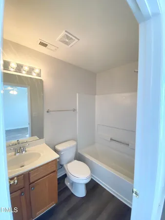 a bathroom with a granite countertop toilet a sink and a bathtub