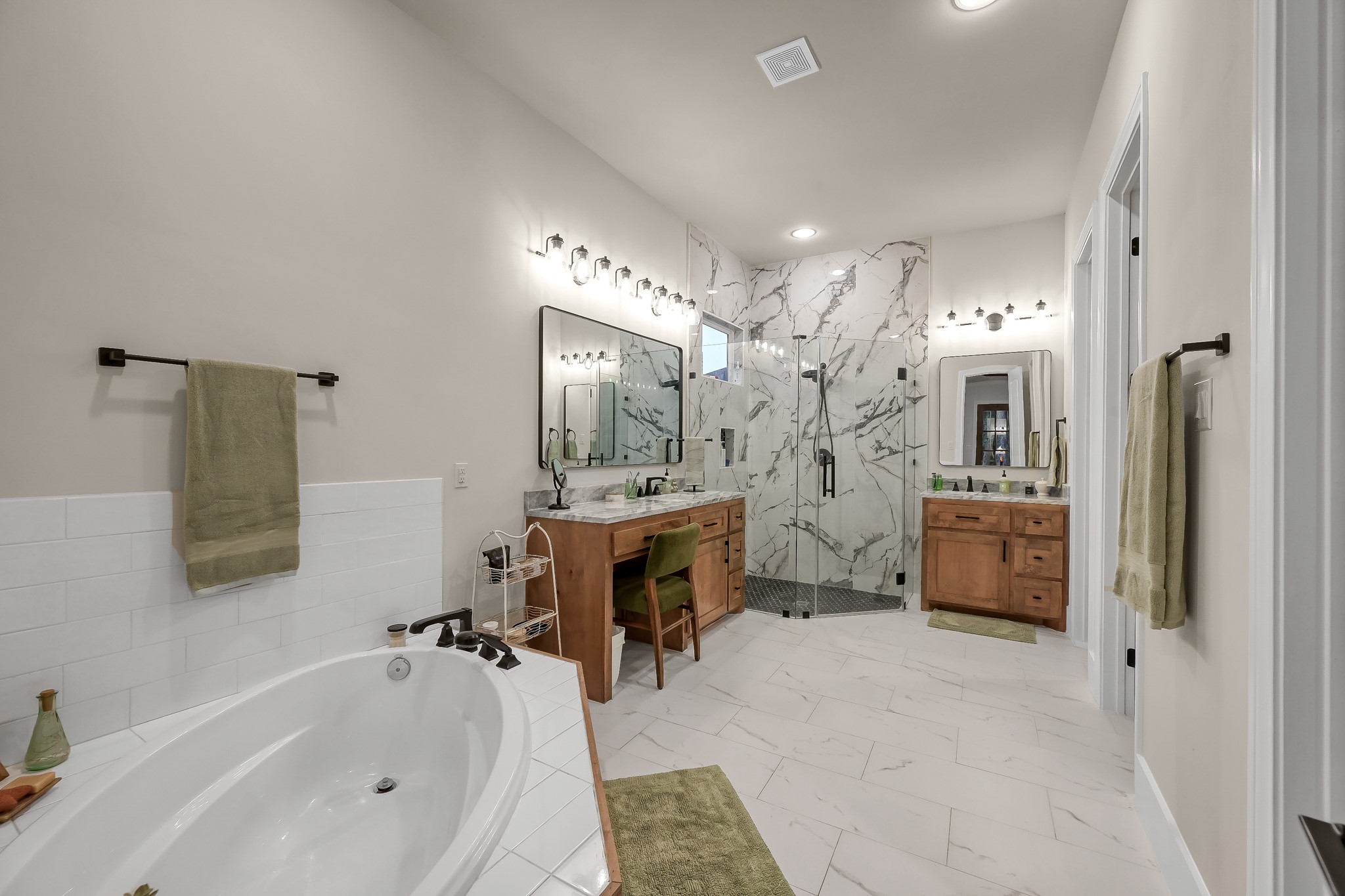 15937 Stagecoach Road Stagecoach, TX 77355 - Photo 23 of 50 This modern bathroom features a spacious layout with a luxurious soaking tub, a large glass-enclosed shower and dual vanities with wooden cabinetry.