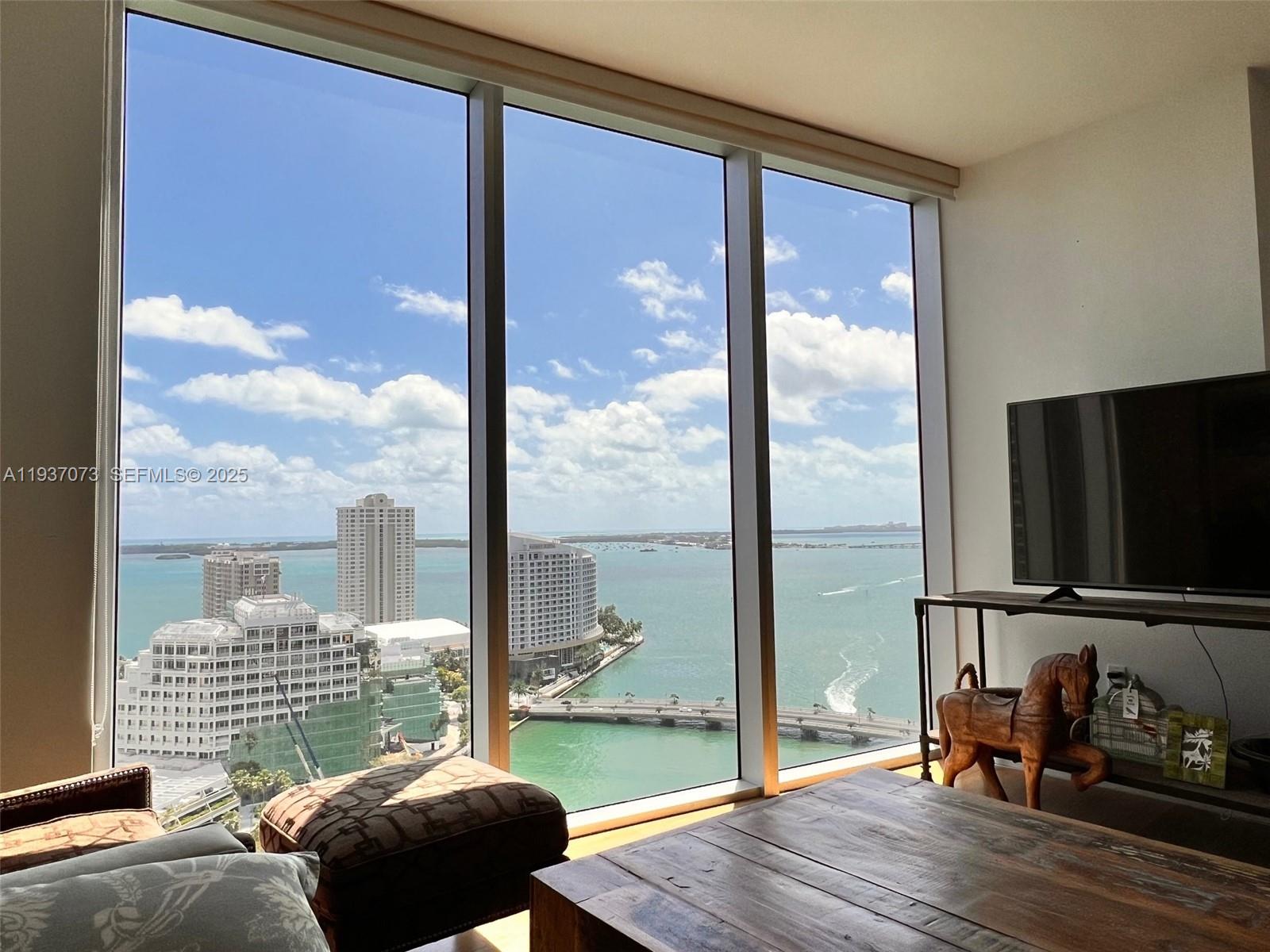 495 Brickell Avenue, Unit 2401 Miami, FL 33131 - Photo 13 of 33 a bedroom with a bed and glass door