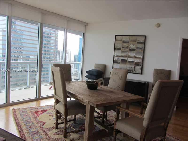 495 Brickell Avenue, Unit 2401 Miami, FL 33131 - Photo 15 of 33 a view of a dining room with furniture window and wooden floor