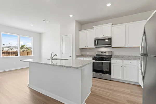 a kitchen with stainless steel appliances granite countertop a stove a sink and a refrigerator