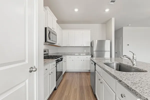 a kitchen with stainless steel appliances granite countertop a sink stove and refrigerator