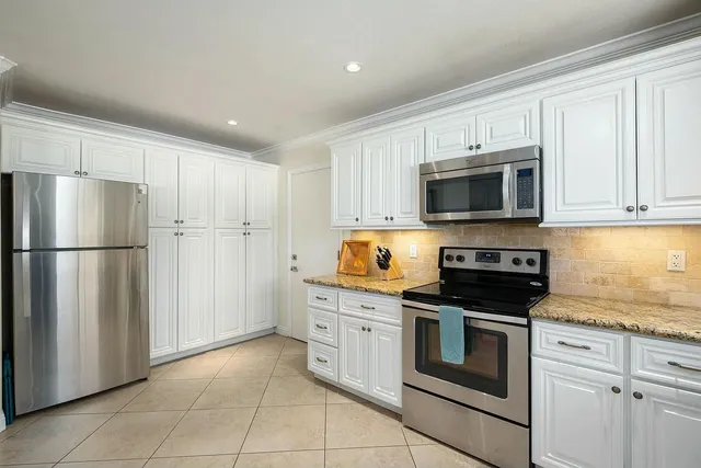 a kitchen with a stove a sink cabinets and a wooden floor