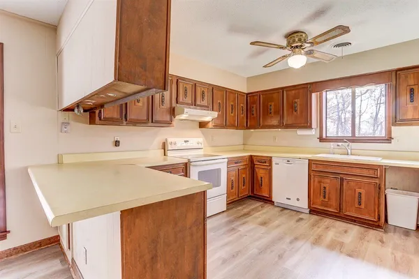 a kitchen with stainless steel appliances sink cabinets and window