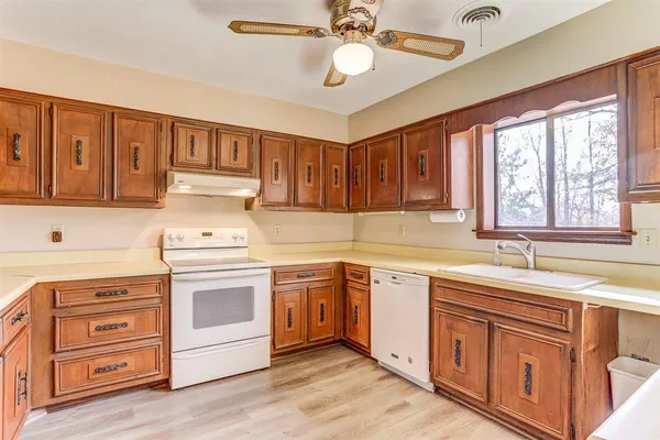a kitchen with granite countertop a sink cabinets stainless steel appliances and a window