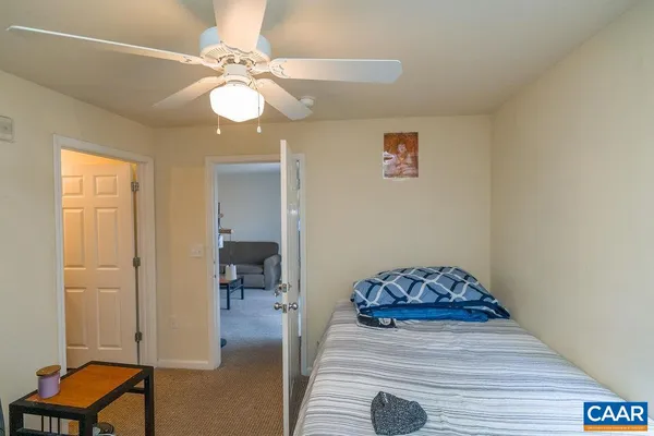 a bedroom with a bed and a computer on a dresser