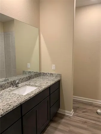 a bathroom with a granite countertop sink and a mirror