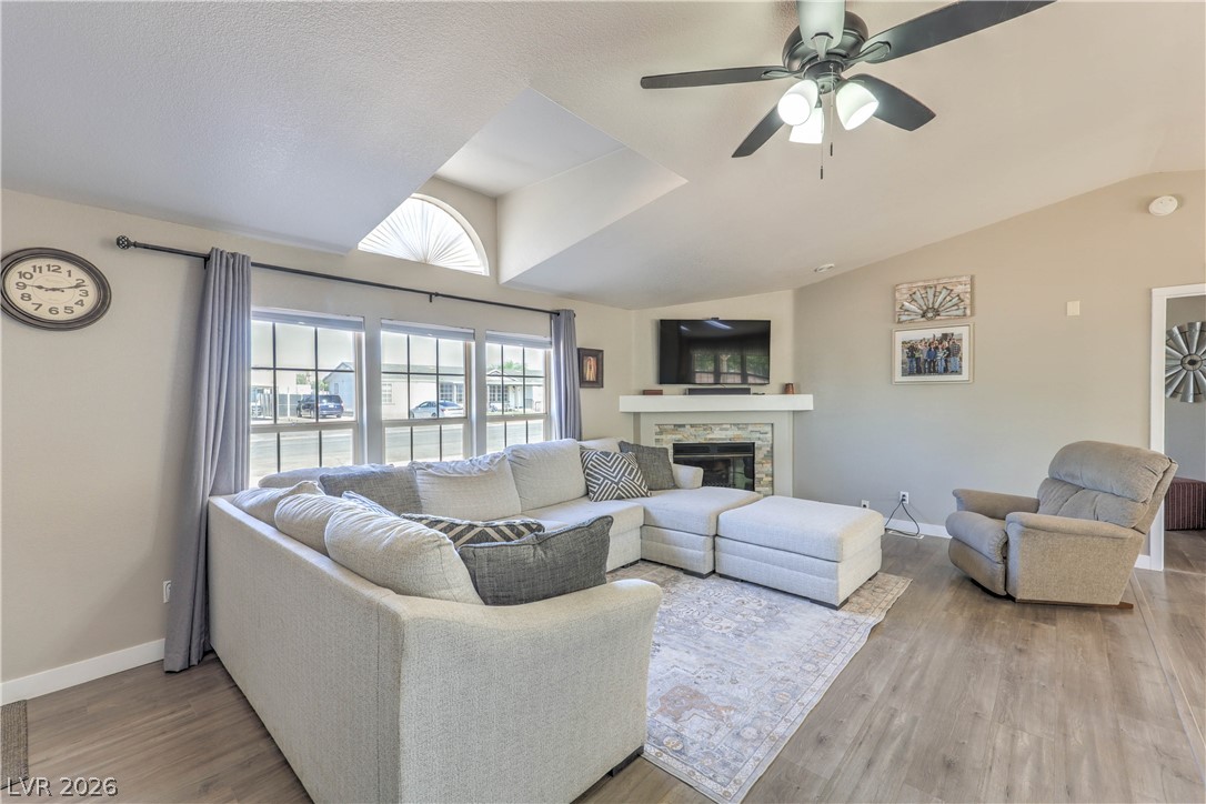 348 Tres Palomas Street Overton, NV 89040 - Photo 8 of 41 A welcoming living room featuring vaulted ceilings, a cozy fireplace, and abundant natural light.
