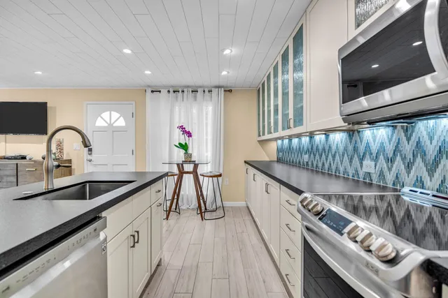 a kitchen with granite countertop a sink and a stove top oven