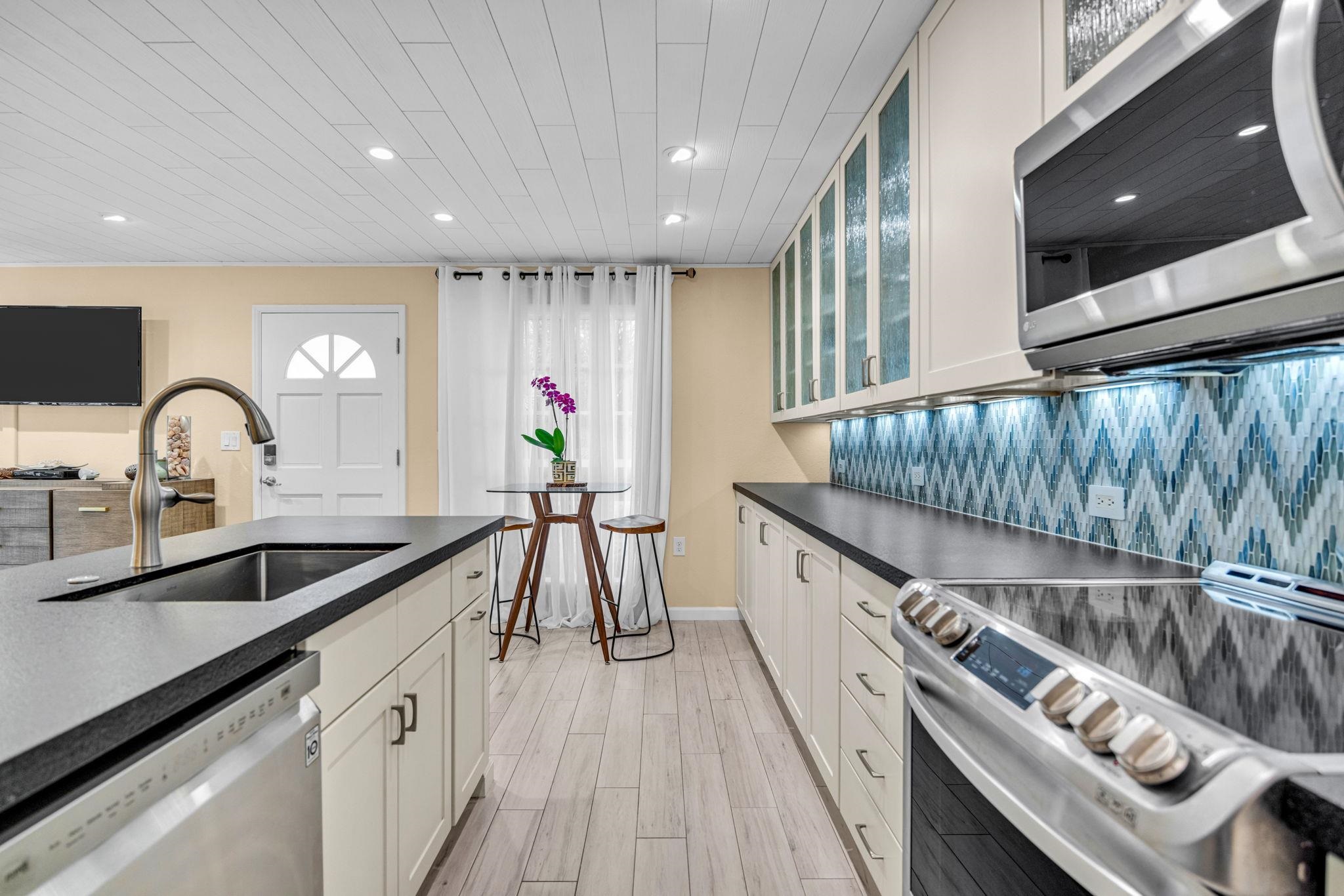 160 Keonekai Road, Unit 8103 Kihei, HI 96753 - Photo 12 of 47 a kitchen with granite countertop a sink and a stove top oven