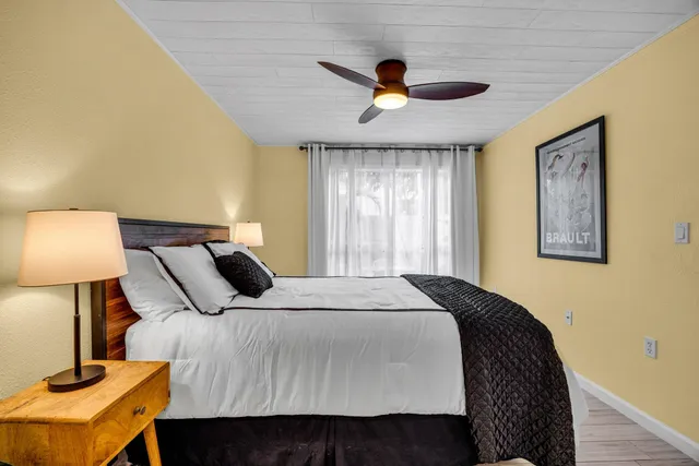 a bedroom with a bed and a lamp on dresser