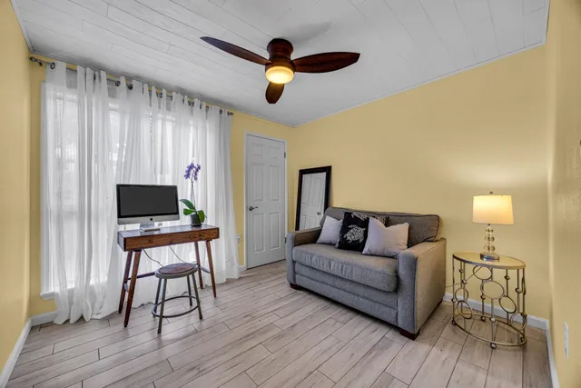 a living room with couches and a flat screen tv with wooden floor