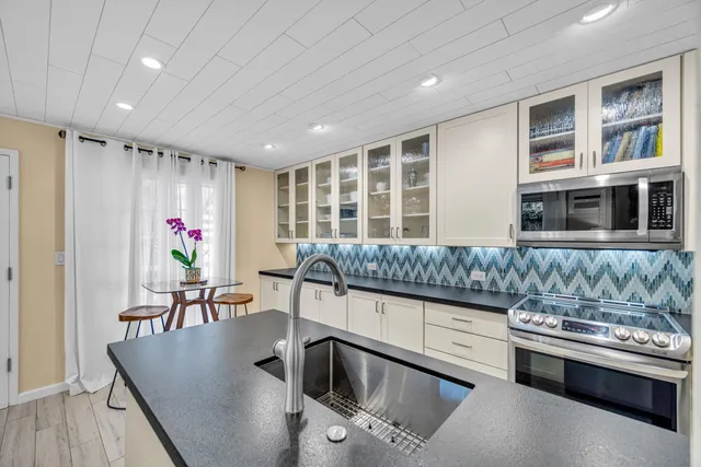 a kitchen with stainless steel appliances granite countertop a sink and a refrigerator