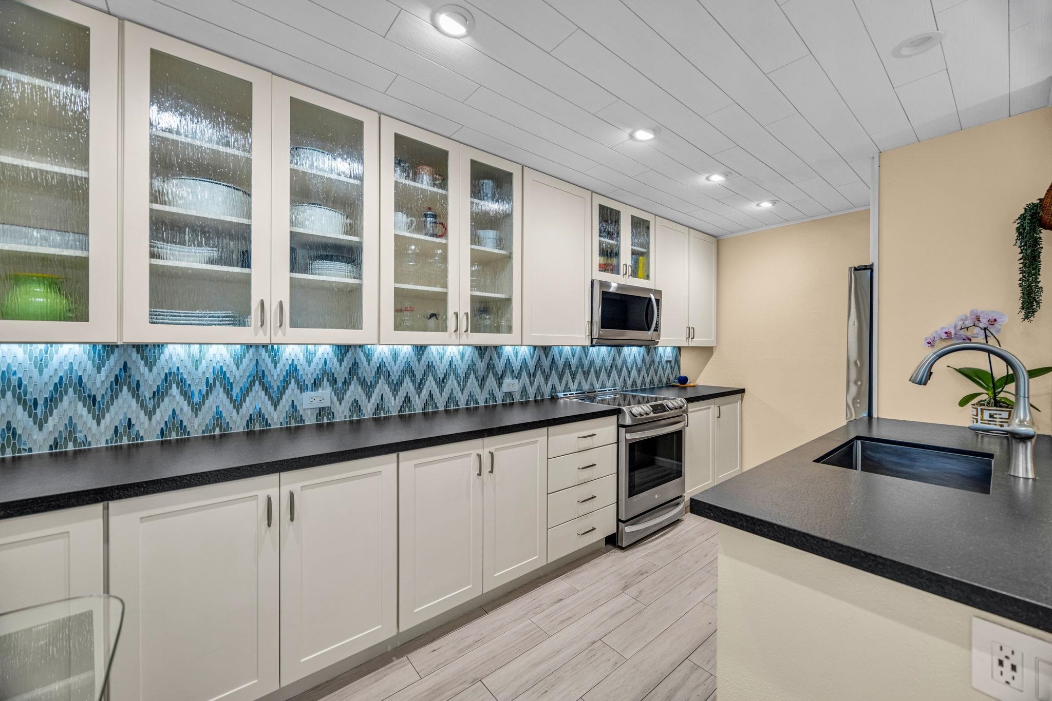 160 Keonekai Road, Unit 8103 Kihei, HI 96753 - Photo 8 of 47 a kitchen with granite countertop cabinets stainless steel appliances a sink and a large window