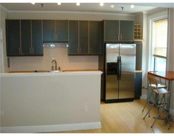 a kitchen with a refrigerator and cabinets
