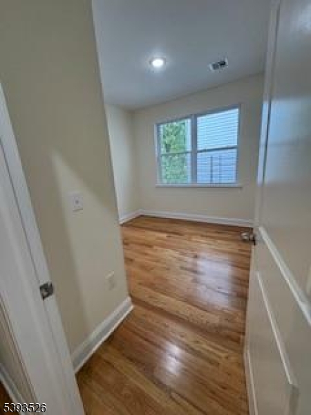38 Blum Street Newark, NJ 07103 - Photo 11 of 15 an empty room with wooden floor and windows