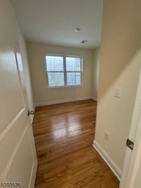 38 Blum Street Newark, NJ 07103 - Photo 12 of 15 a view of an empty room with wooden floor and a window