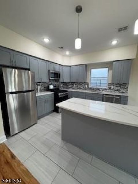 38 Blum Street Newark, NJ 07103 - Photo 3 of 15 a large kitchen with stainless steel appliances granite countertop a refrigerator a sink a stove a microwave and a refrigerator
