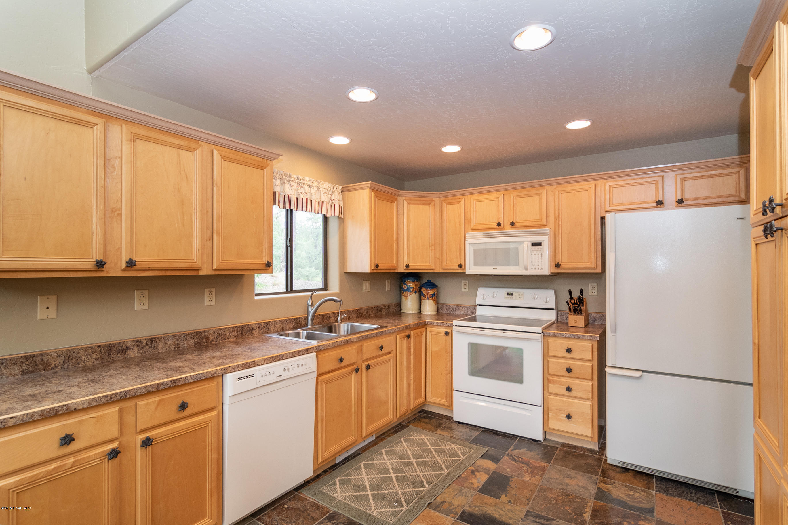 4680 South Stoney Ridge Road Prescott, AZ 86303 - Photo 22 of 39 a kitchen with a sink a refrigerator and white cabinets