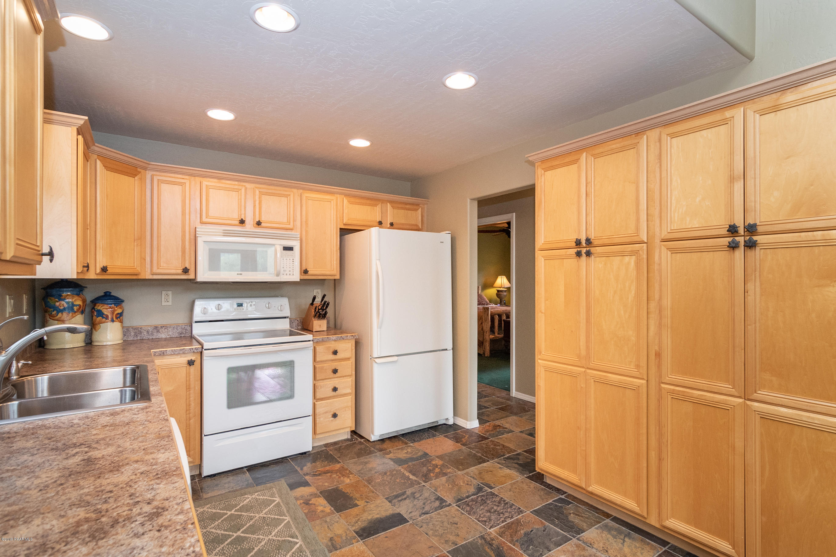 4680 South Stoney Ridge Road Prescott, AZ 86303 - Photo 23 of 39 a kitchen with refrigerator a microwave and white cabinets