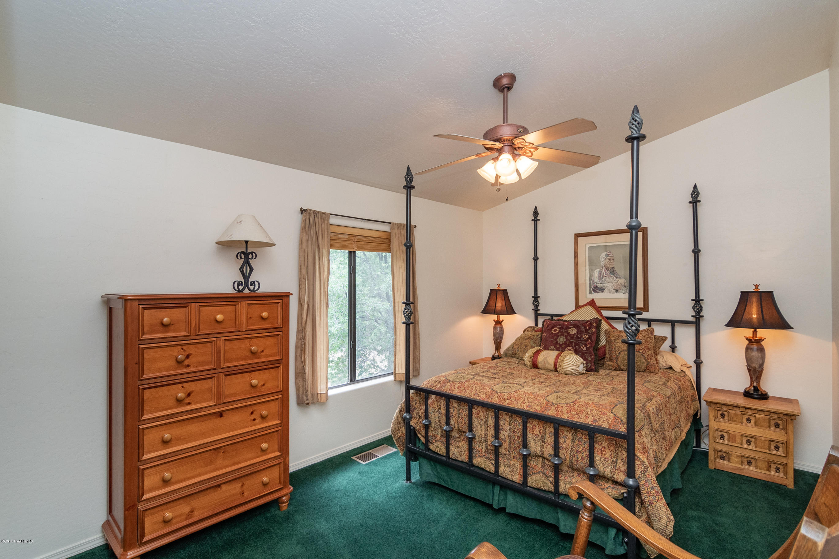 4680 South Stoney Ridge Road Prescott, AZ 86303 - Photo 35 of 39 a bedroom with a bed a chandelier and dresser