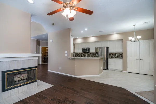a view of an empty room with wooden floor and a fireplace