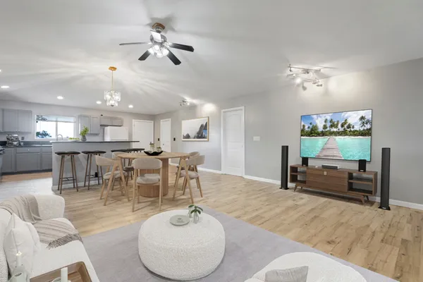 a living room with furniture kitchen view and a chandelier