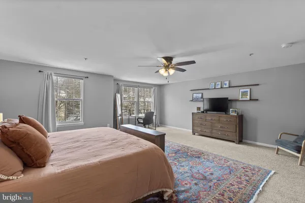 a bedroom with a bed and a large window