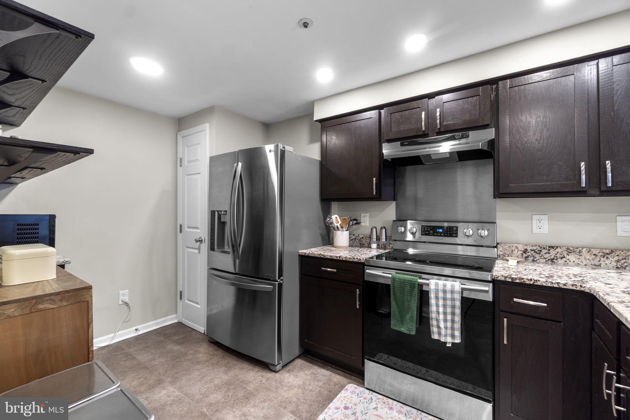 6025 Weekend Way, Unit 43 Columbia, MD 21044 - Photo 7 of 37 a kitchen with stainless steel appliances granite countertop a stove a refrigerator and a sink