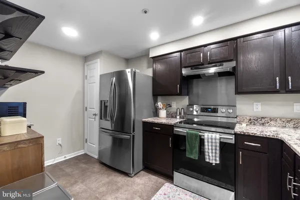 a kitchen with stainless steel appliances granite countertop a sink stove and cabinets