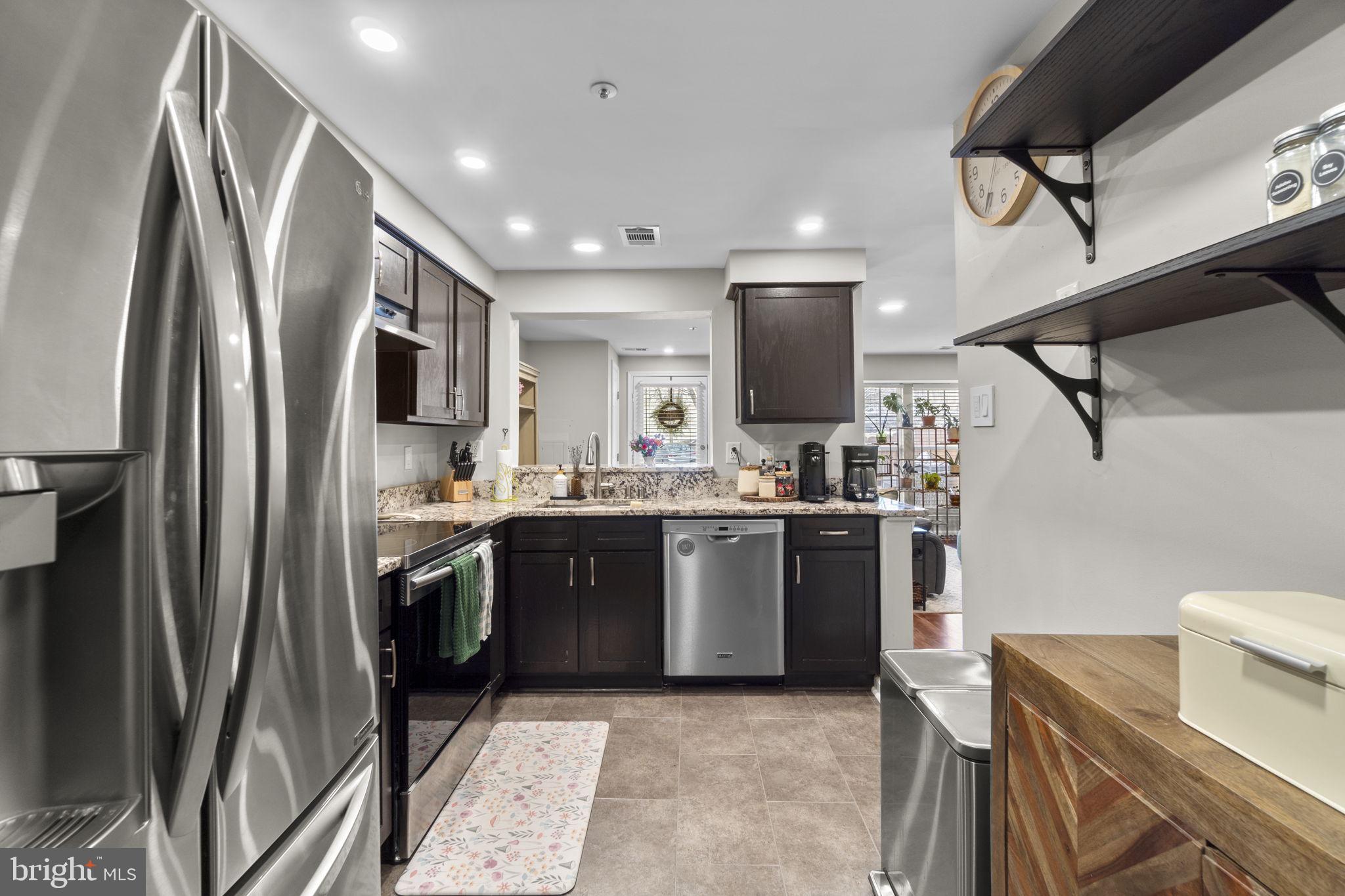 6025 Weekend Way, Unit 43 Columbia, MD 21044 - Photo 10 of 37 a kitchen with stainless steel appliances granite countertop a refrigerator a stove and a sink