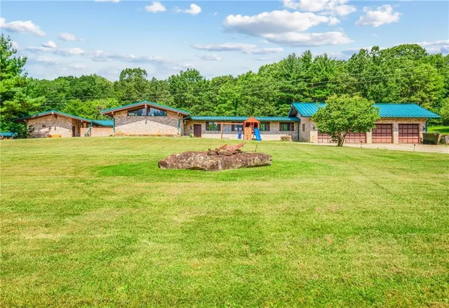 a front view of a house with a yard and trees
