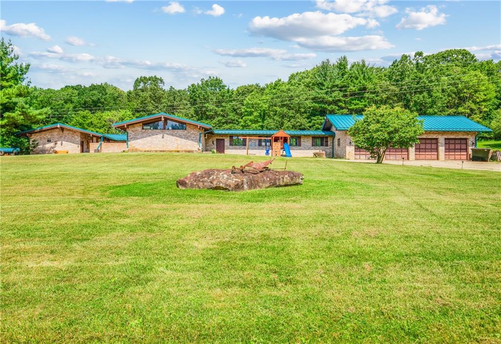 a front view of a house with a yard and trees