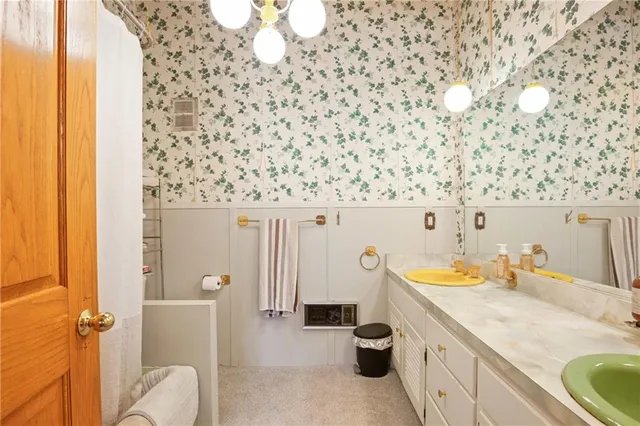 a bathroom with a sink a toilet and shower curtain