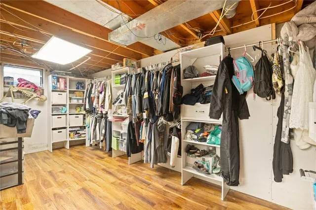 a view of walk in closet with clothes and shoes