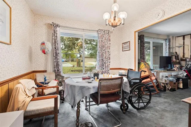 a living room with furniture chandelier and a large window