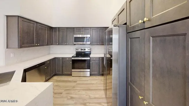 a kitchen with stainless steel appliances granite countertop a refrigerator and a sink