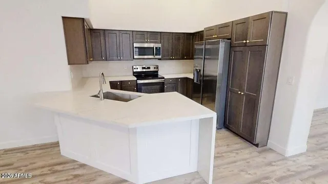 a kitchen with stainless steel appliances a refrigerator stove microwave and sink