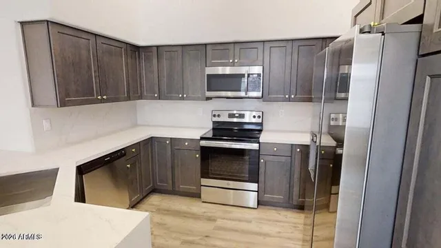 a kitchen with granite countertop a refrigerator stove and microwave