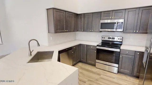 a kitchen with granite countertop a stove and a microwave with wooden floor