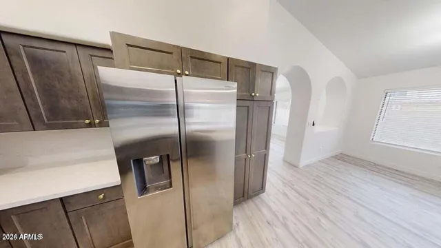 a kitchen with stainless steel appliances a refrigerator and a wooden floor