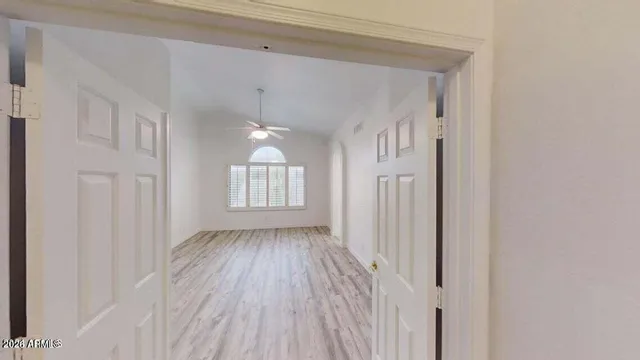 a view of a hallway with wooden floor and staircase