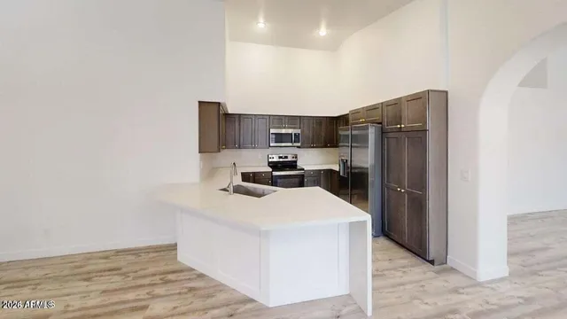 a kitchen with stainless steel appliances a refrigerator sink and microwave