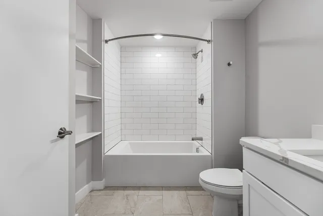 a bathroom with a shower a toilet and a tub