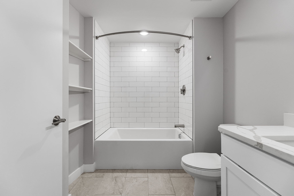 59 Mill Street, Unit 203 Woburn, MA 01801 - Photo 14 of 19 a bathroom with a shower a toilet and a tub